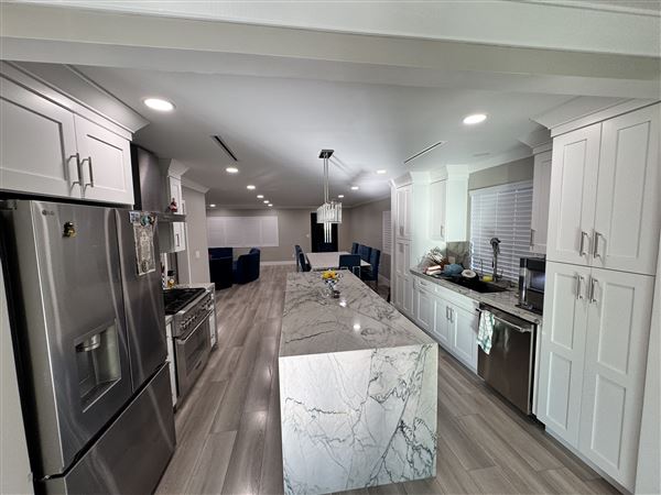 Modern Valley Family Home (2/25/2026 - Credits: Modern open-concept kitchen with waterfall marble island  Clean recessed lighting throughout  Neutral gray + white palette (camera friendly)  Large dining setup (great for commercial shoots)  Sliding glass doors connecting indoor/outdoor  Outdoo)