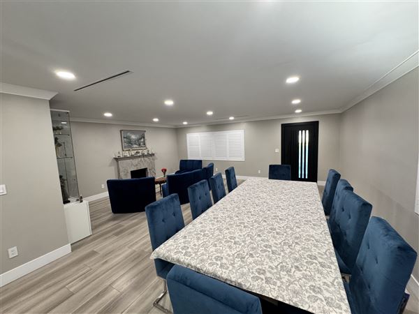 Modern Valley Family Home (2/25/2026 - Credits: Modern open-concept kitchen with waterfall marble island  Clean recessed lighting throughout  Neutral gray + white palette (camera friendly)  Large dining setup (great for commercial shoots)  Sliding glass doors connecting indoor/outdoor  Outdoo)