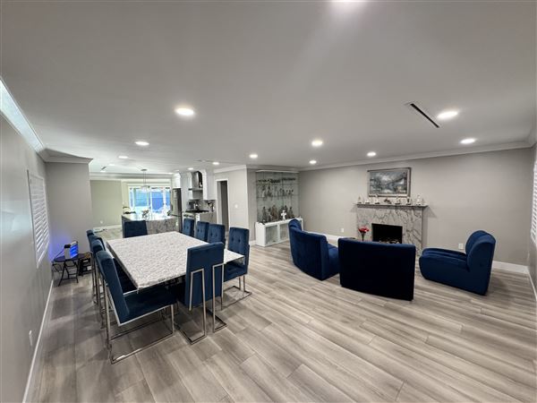 Modern Valley Family Home (2/25/2026 - Credits: Modern open-concept kitchen with waterfall marble island  Clean recessed lighting throughout  Neutral gray + white palette (camera friendly)  Large dining setup (great for commercial shoots)  Sliding glass doors connecting indoor/outdoor  Outdoo)